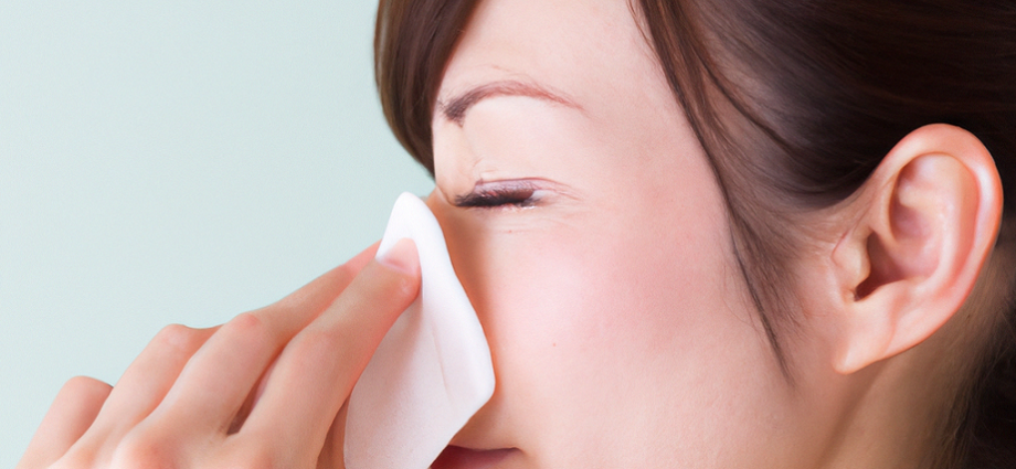 Person blowing their nose with a tissue, a common action for those experiencing symptoms of Non-Allergic Rhinitis.